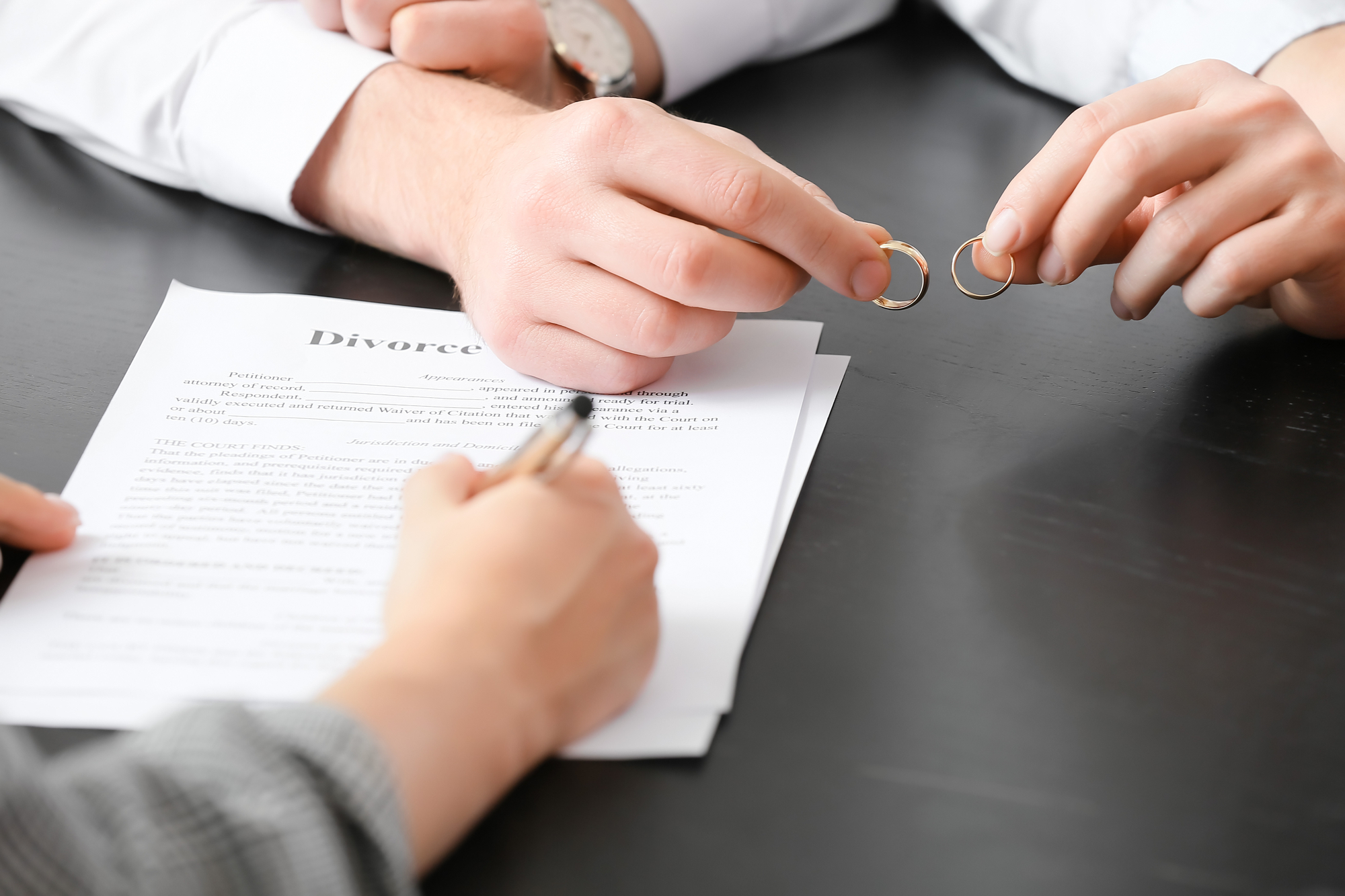 Couple taking off wedding rings in lawyer's office