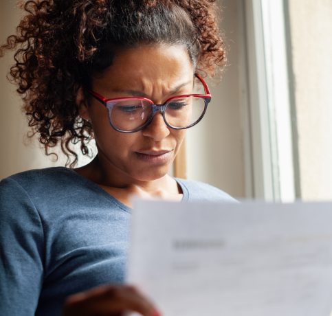 Portrait of worried black woman standing beside window